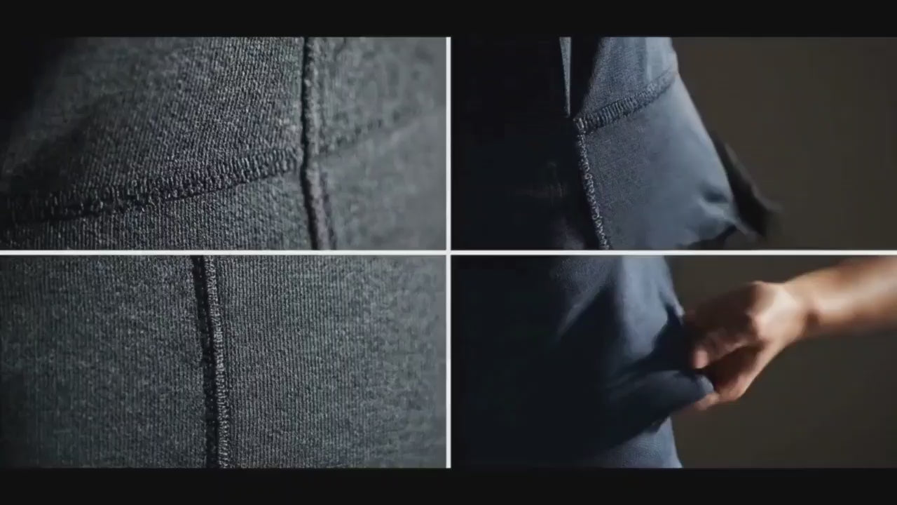 Load video: Full-body video of a male models wearing a solid bamboo fabric crew-neck t-shirt and neutral trousers, standing in a clean, minimal indoor setting. The models slowly shifts postures and turns slightly, showing the natural drape, smooth texture, and relaxed fit of the t-shirt under soft, even lighting.